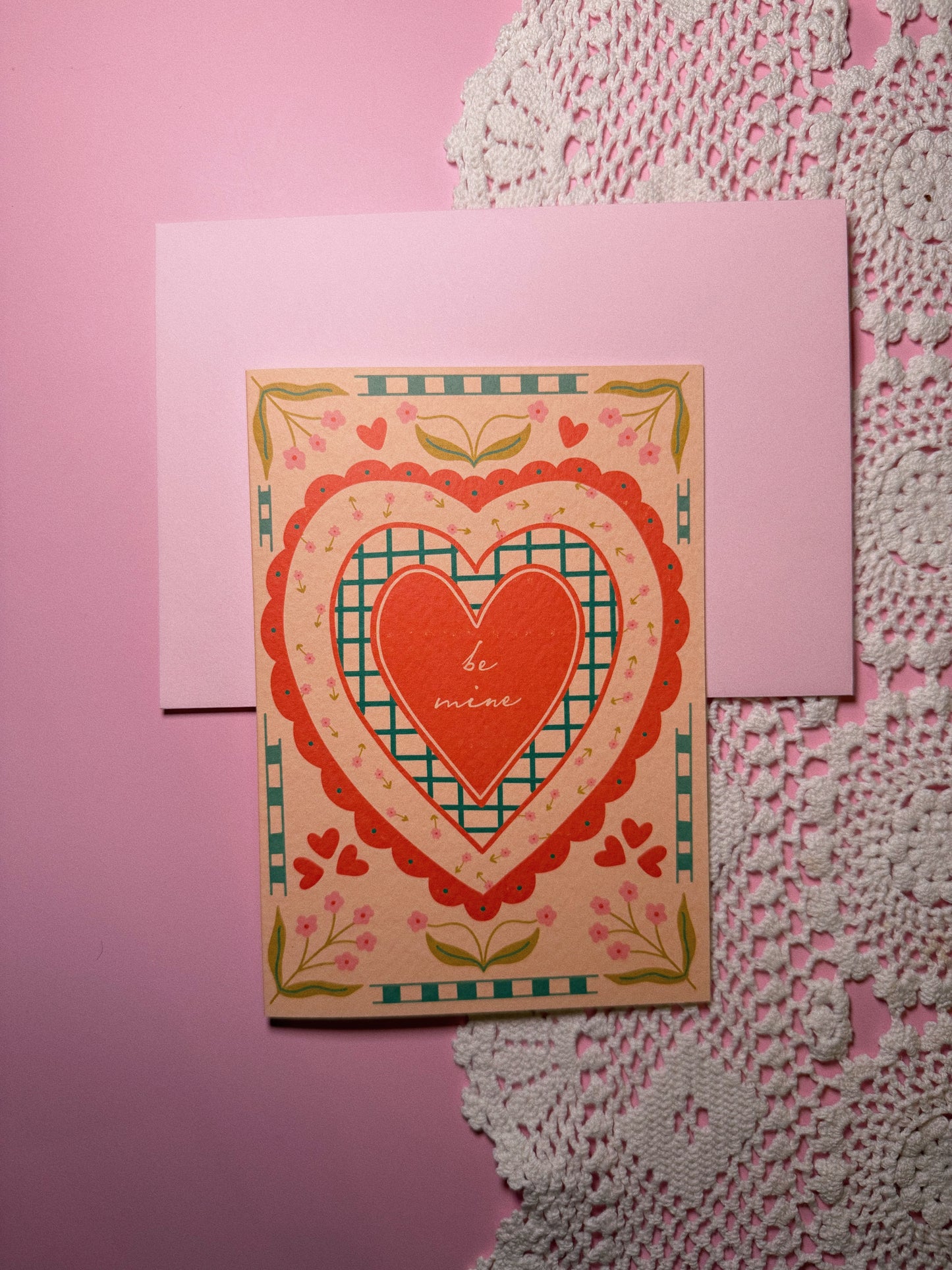 Red Heart Card on a tan background with Pink Envelope with the words Be Mine in the center set in a vintage style
