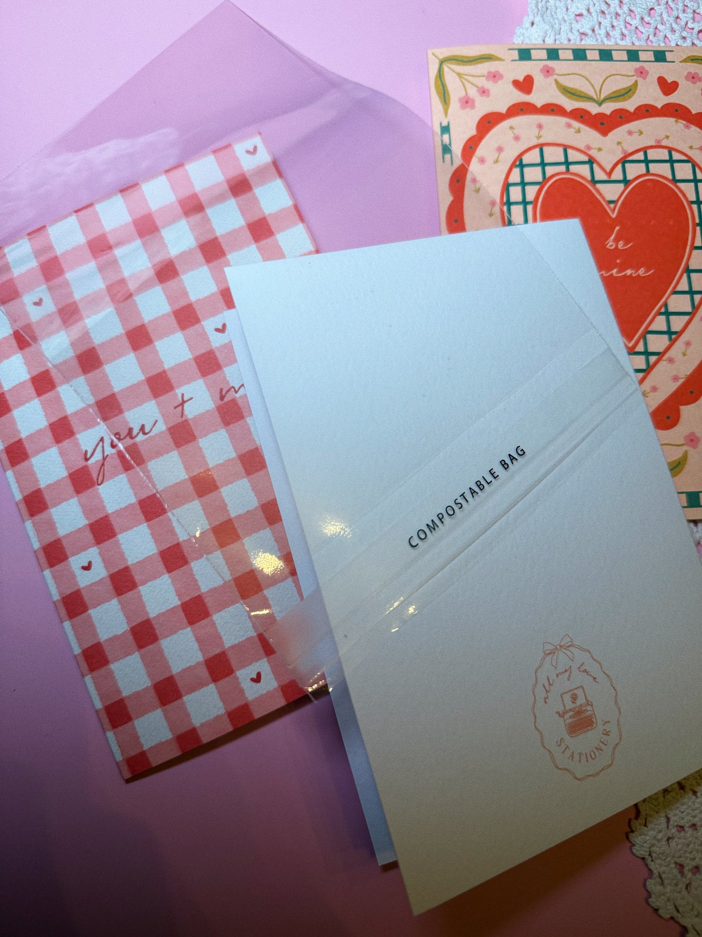 Three greeting cards with the compostable clear plastic sleeve being displayed that the greeting cards come in